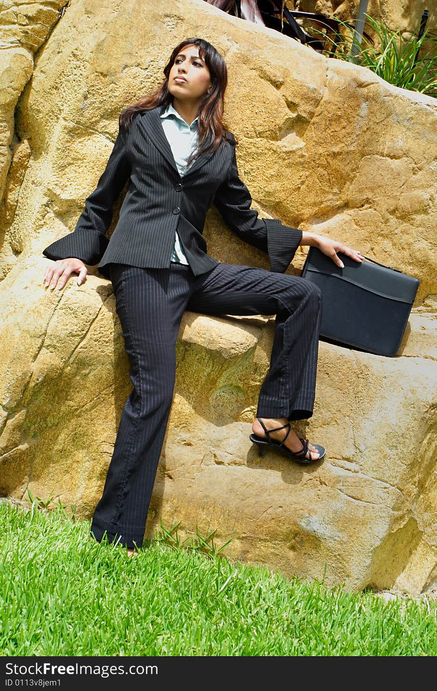 Young Businesswoman sitting on a rock wall. Young Businesswoman sitting on a rock wall