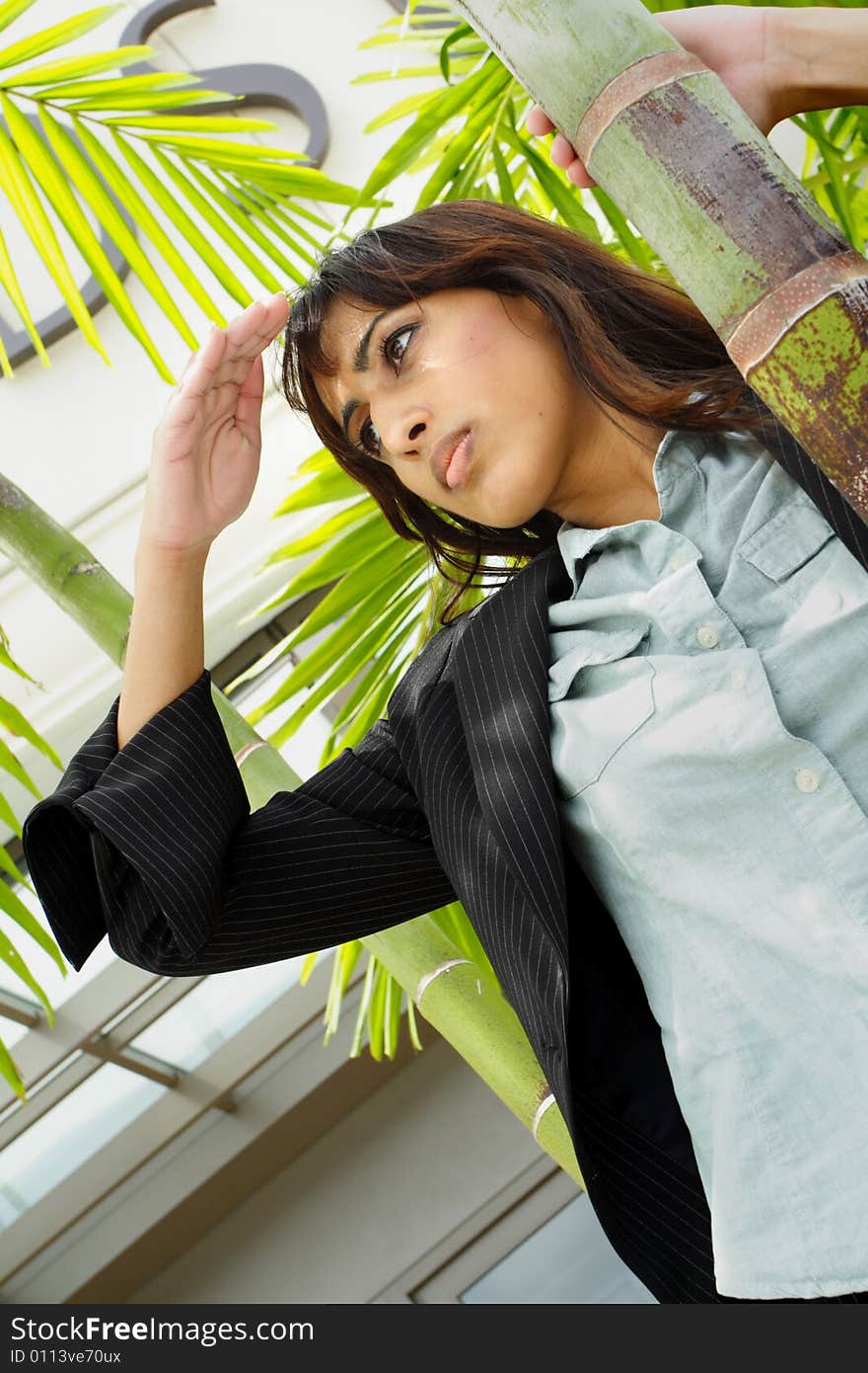 Young female looking away and using her hand to block the light. Young female looking away and using her hand to block the light.