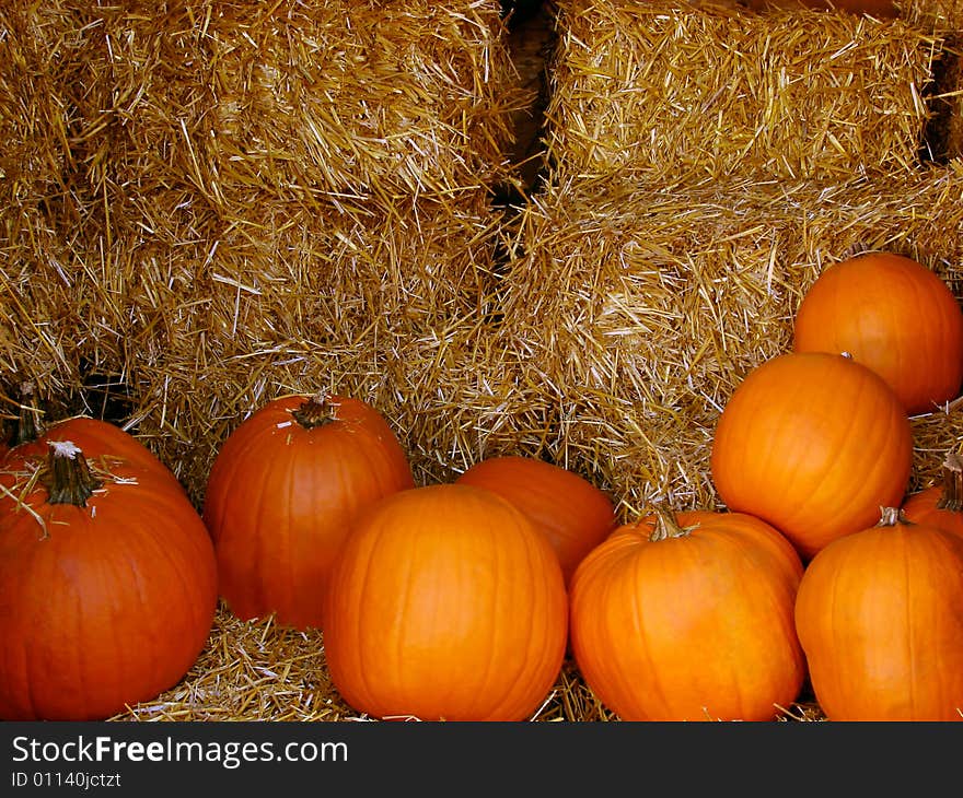 Pumpkins piled up on hay in an autumn scene. Pumpkins piled up on hay in an autumn scene