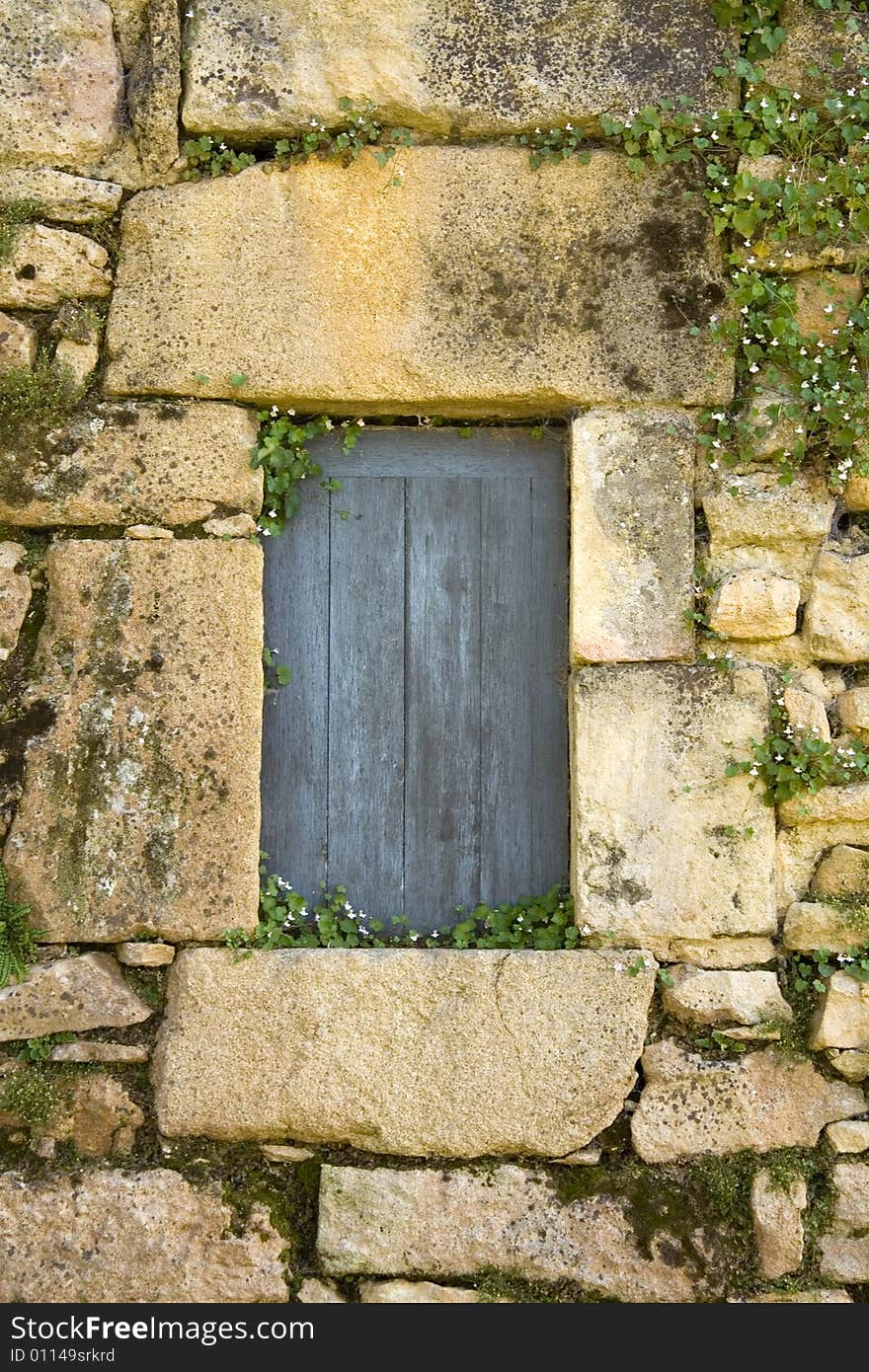 Small blue doorway set into an old brick wall