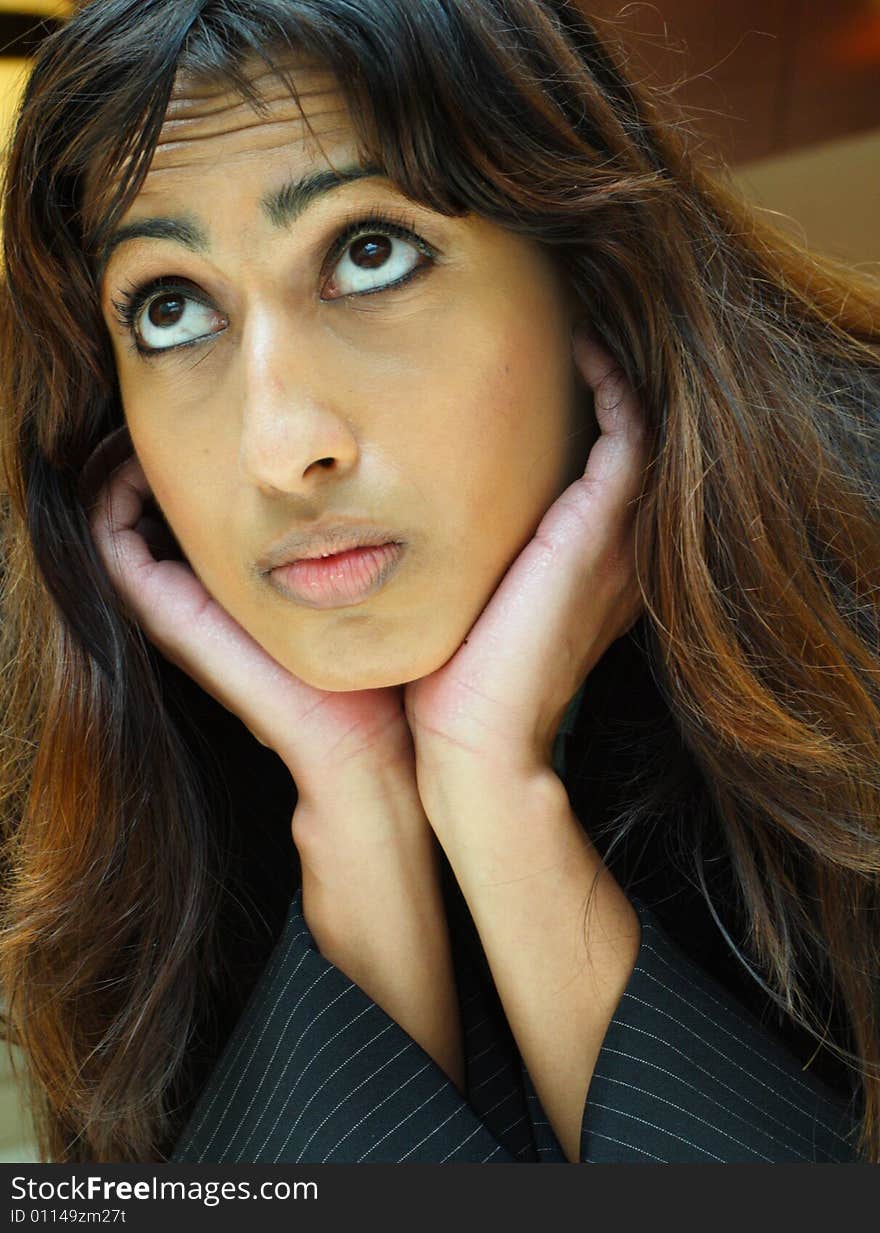 Young Islamic Businesswoman resting her head on her hands and looking upward. Young Islamic Businesswoman resting her head on her hands and looking upward.