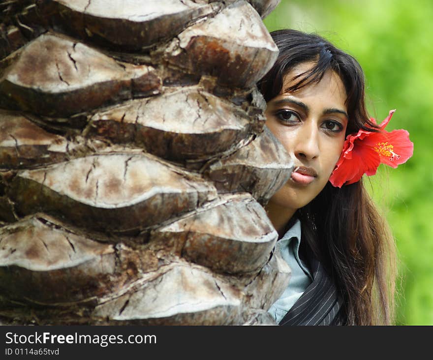 Woman sticking out from behind a tree.