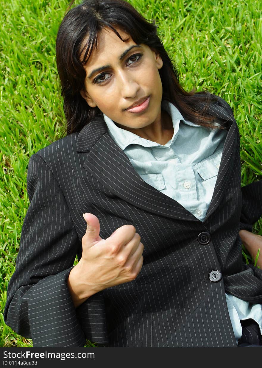 Woman on the grass showing a thumbs up gesture. Woman on the grass showing a thumbs up gesture.