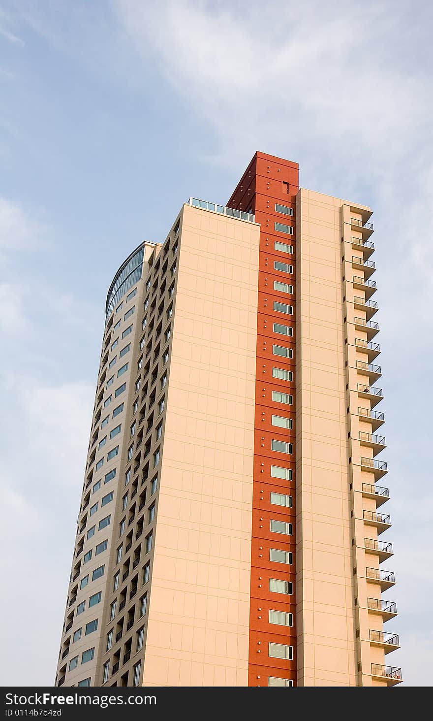 A colorful high rise condo in early morning light with sky and clouds. A colorful high rise condo in early morning light with sky and clouds