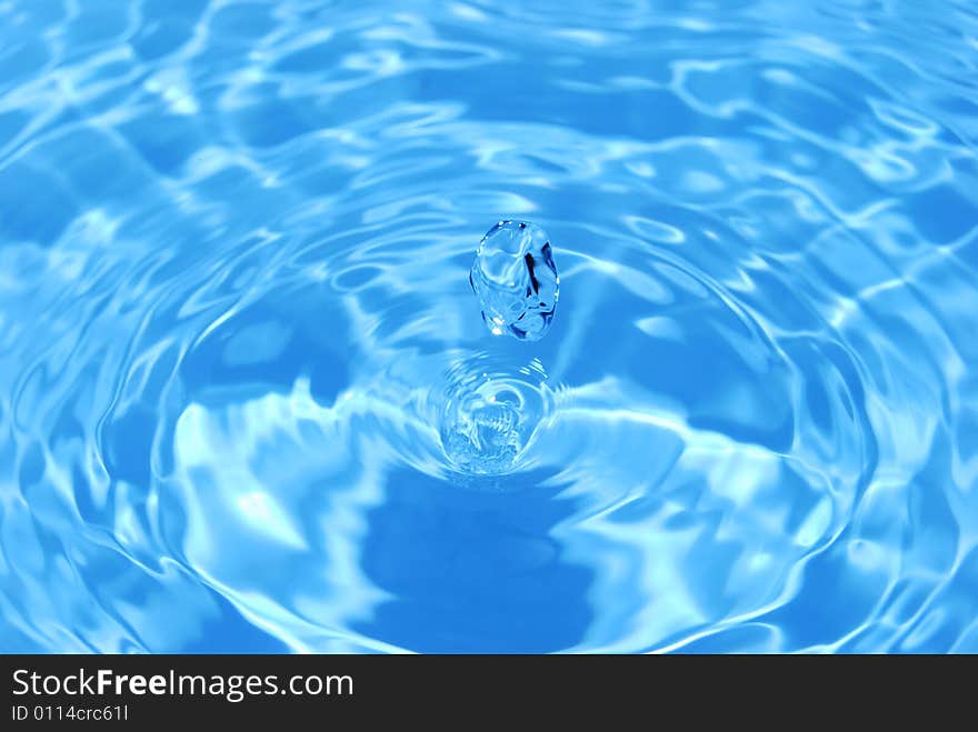 Is bright-blue transparent water drop close up. Is bright-blue transparent water drop close up