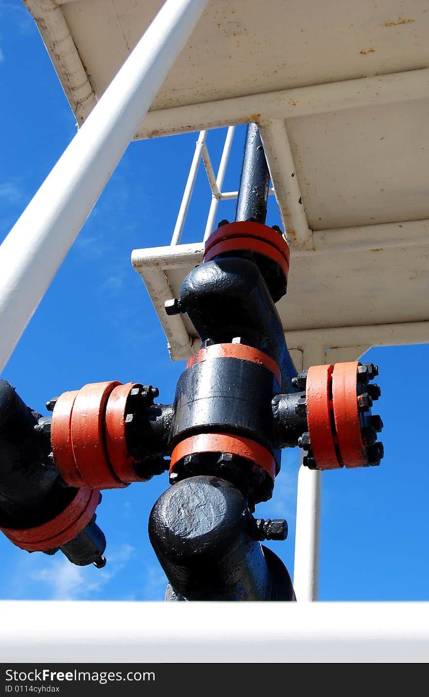 Industrial unit of an oil well close up, on a background of the turquoise sky. Industrial unit of an oil well close up, on a background of the turquoise sky.