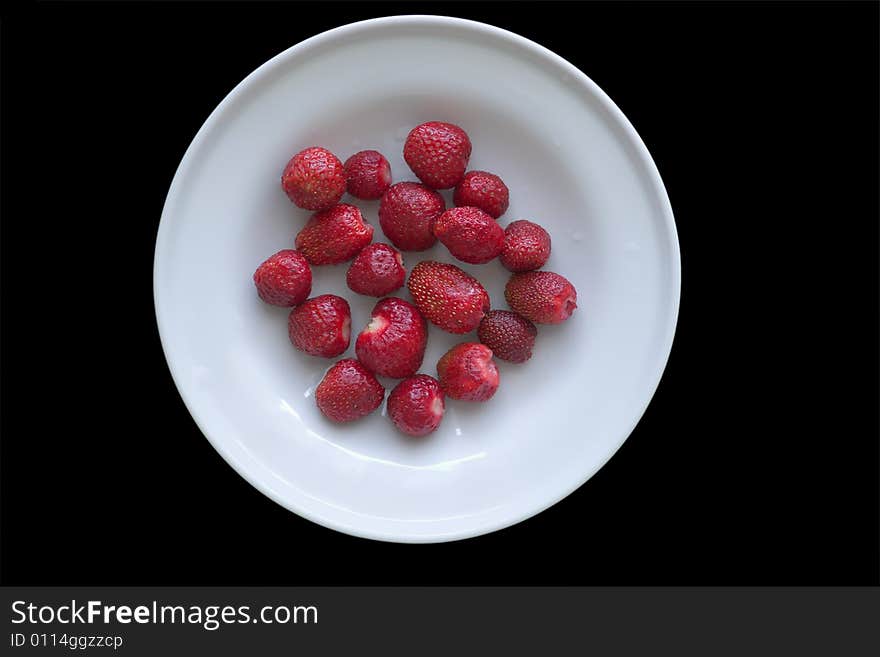 Plate with strawberries isolated on black