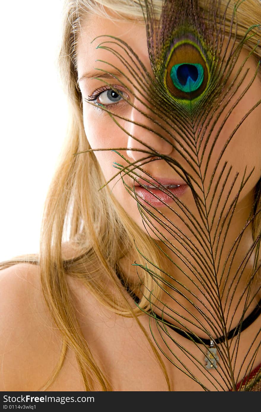 Close-up portrait of surprised girl with open mouth, peacock a feather closes eye