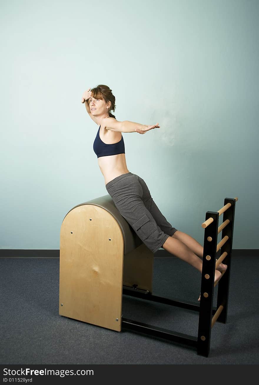 Athletic Woman Exercising and Stretching on Gym Equipment