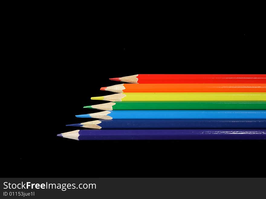 Seven pencils of all colors of a rainbow lay on a black background. Seven pencils of all colors of a rainbow lay on a black background.