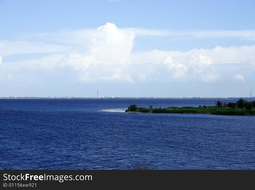 Calm river on background cloud on blue sky