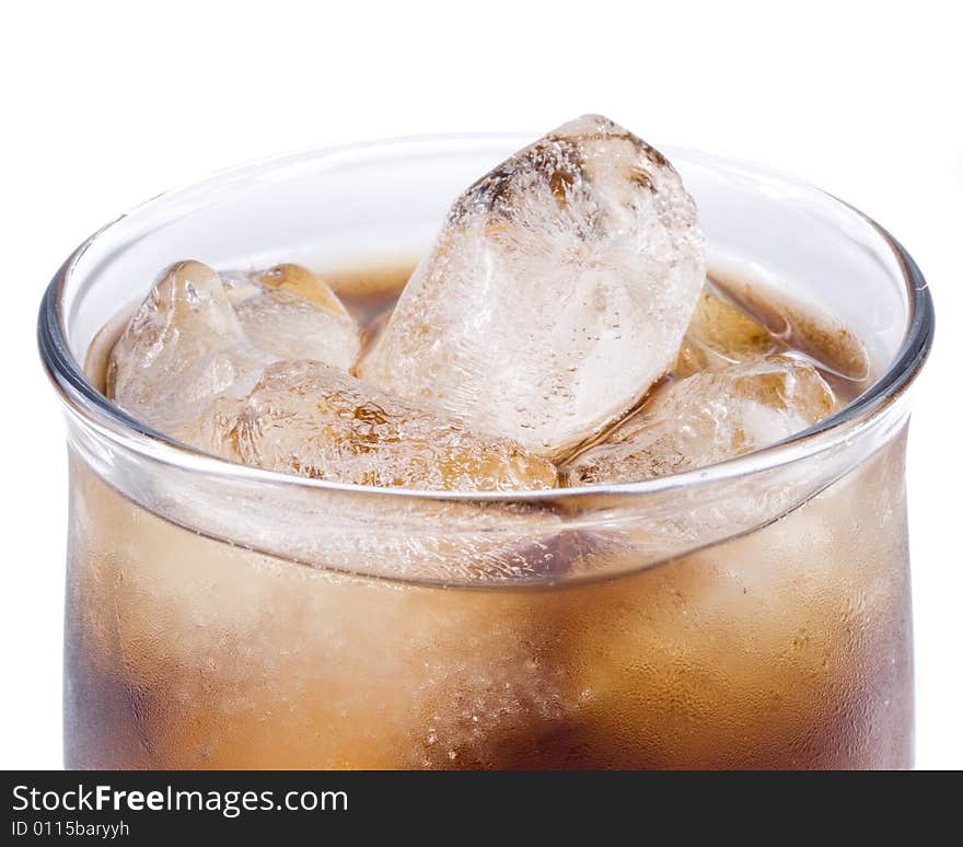 Cold fizzy cola with ice in a glass. Close up.