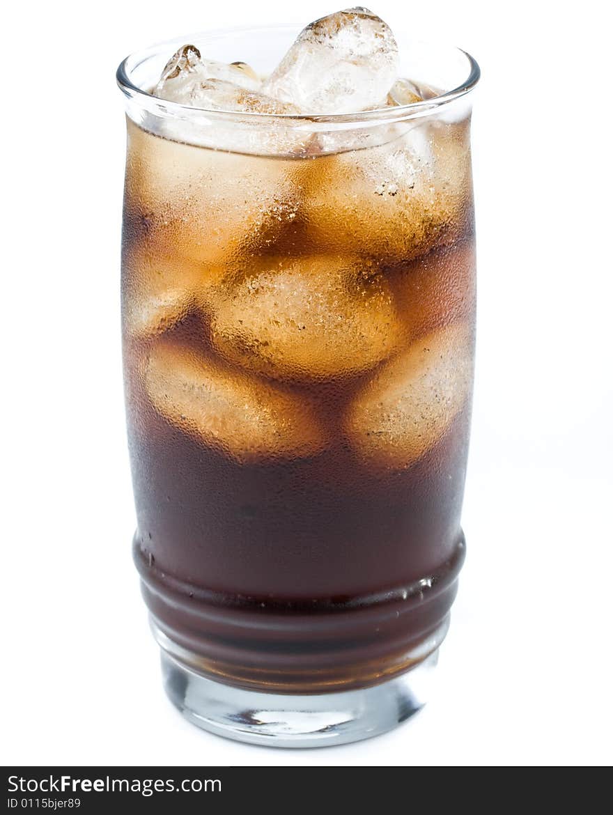 Cold fizzy cola with ice in a glass. Close up.