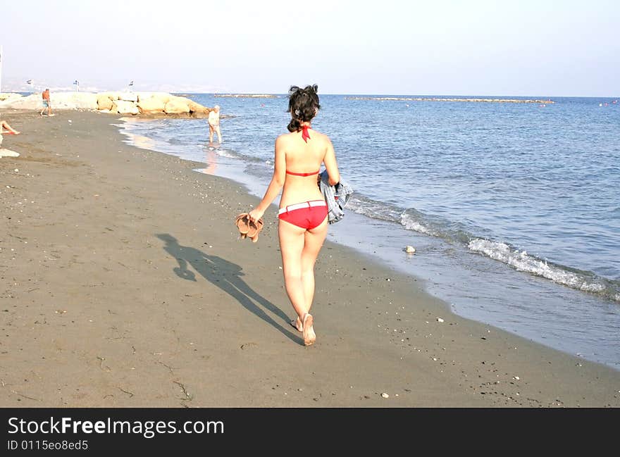 Pretty girl in red bikini on the beach.