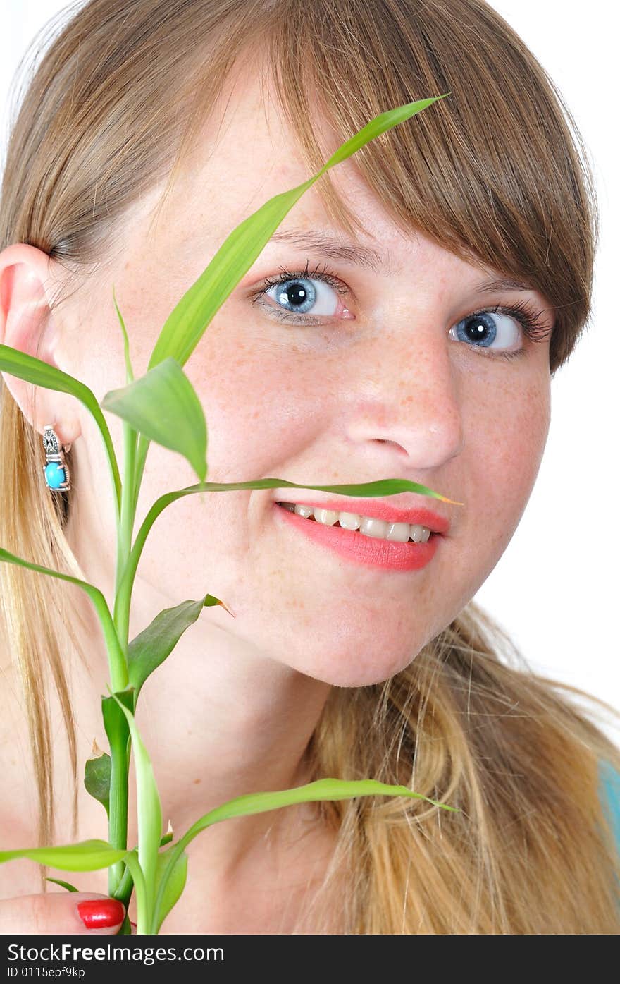 Portrait of the blue-eyed girl with green plant on white background