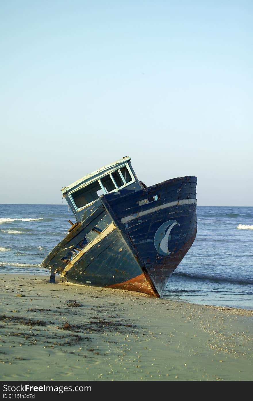 Wooden fishing boat neglected on the beach. Wooden fishing boat neglected on the beach