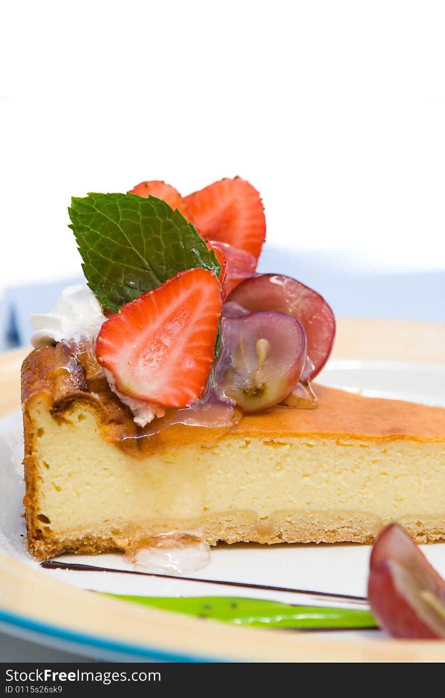 A piece of cheesecake with strawberry and grape