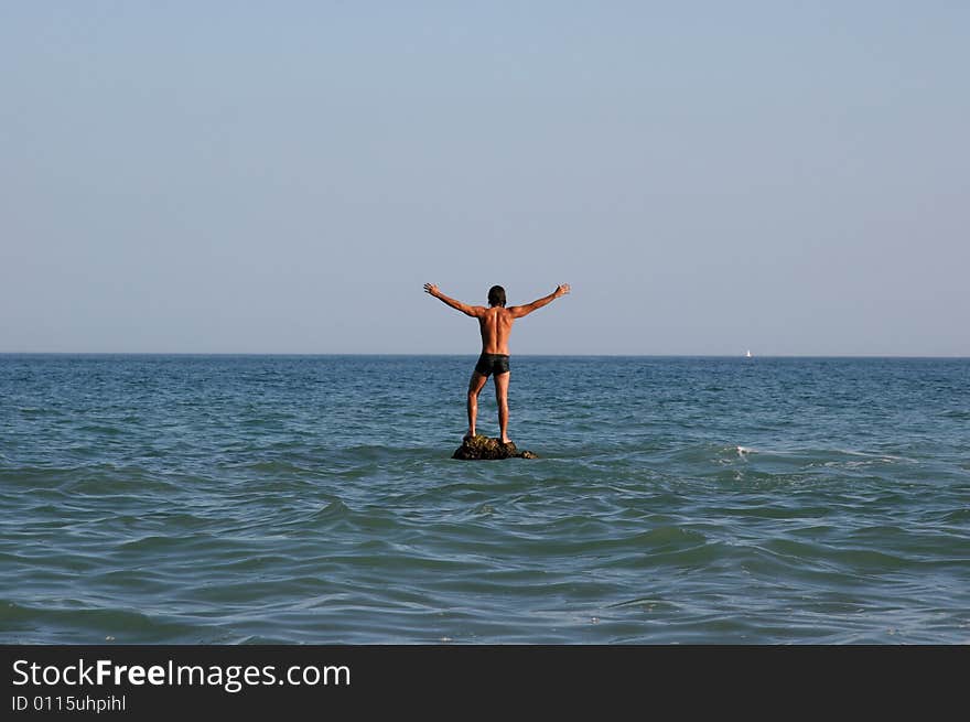 A man is standing in the sea. A man is standing in the sea