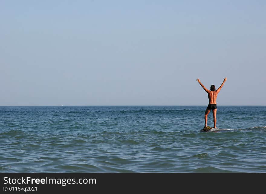 A man is standing in the sea. A man is standing in the sea