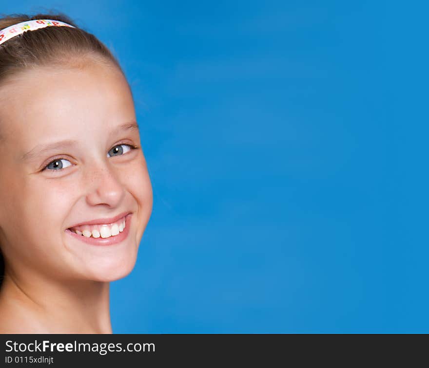 Close-up portrait of pretty young girl on blue background