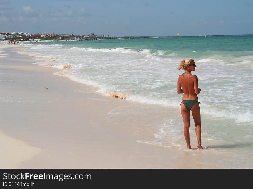 topless woman at beach showing her back and profile. topless woman at beach showing her back and profile