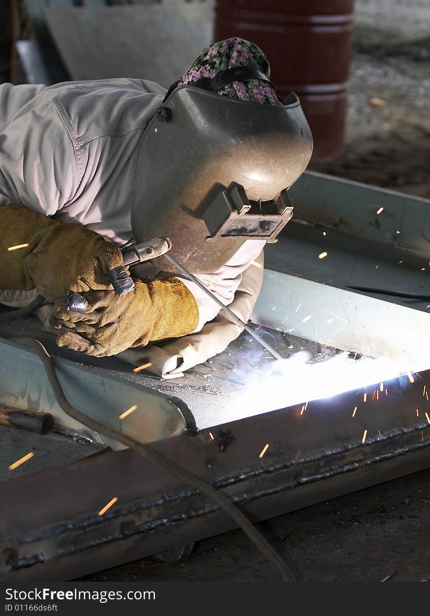 A welder working at shipyard during day shift