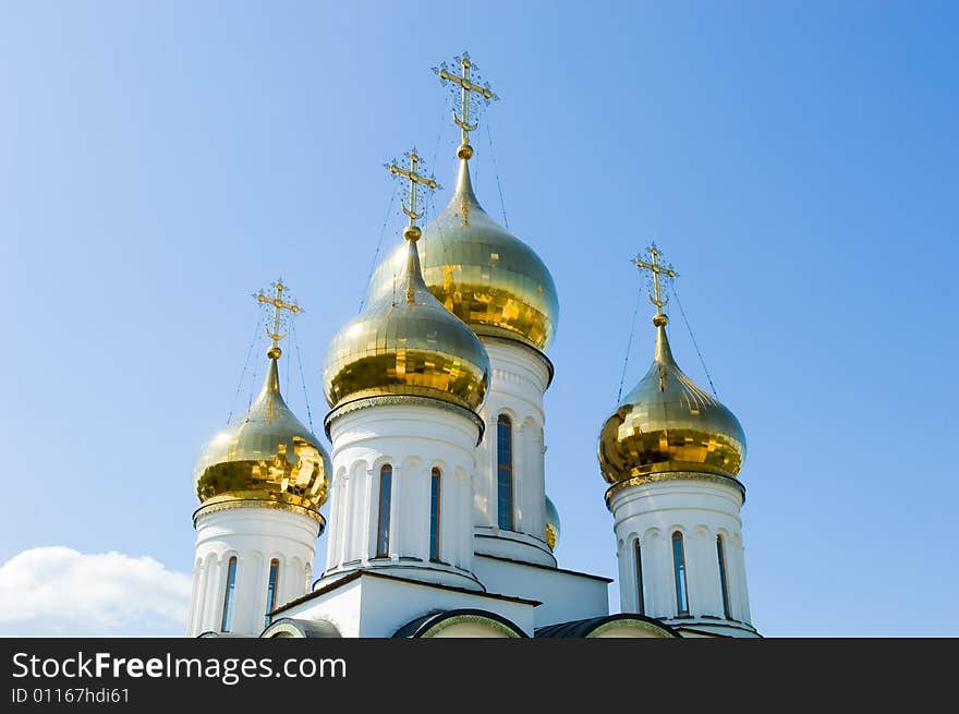 Golden church domes on blue sky background