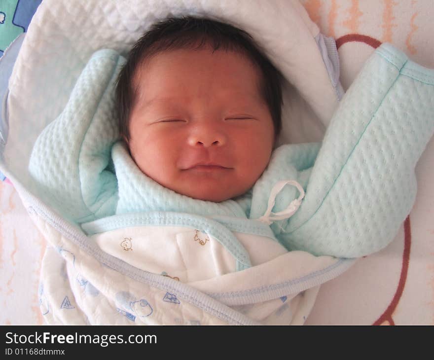 An infant is smiling while she is sleeping. An infant is smiling while she is sleeping