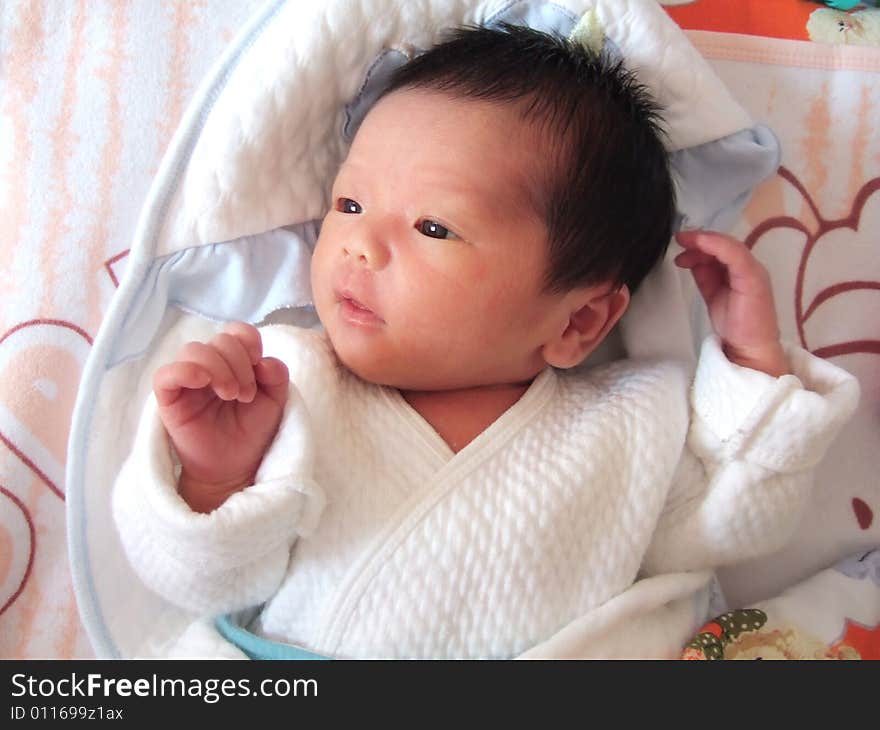 Lovely Infant in white on a bed