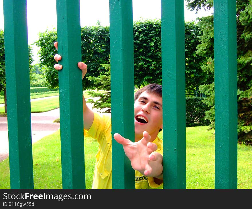 Photo of the young man behind a fence.