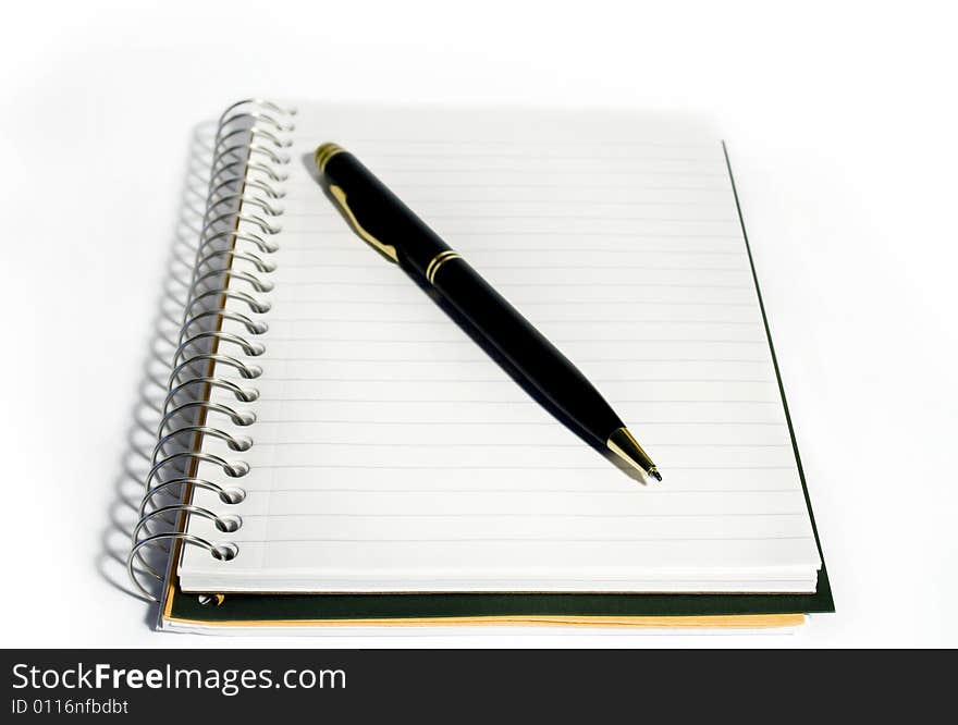 Spiral-bound notebook with ballpoint pen on white background. Spiral-bound notebook with ballpoint pen on white background