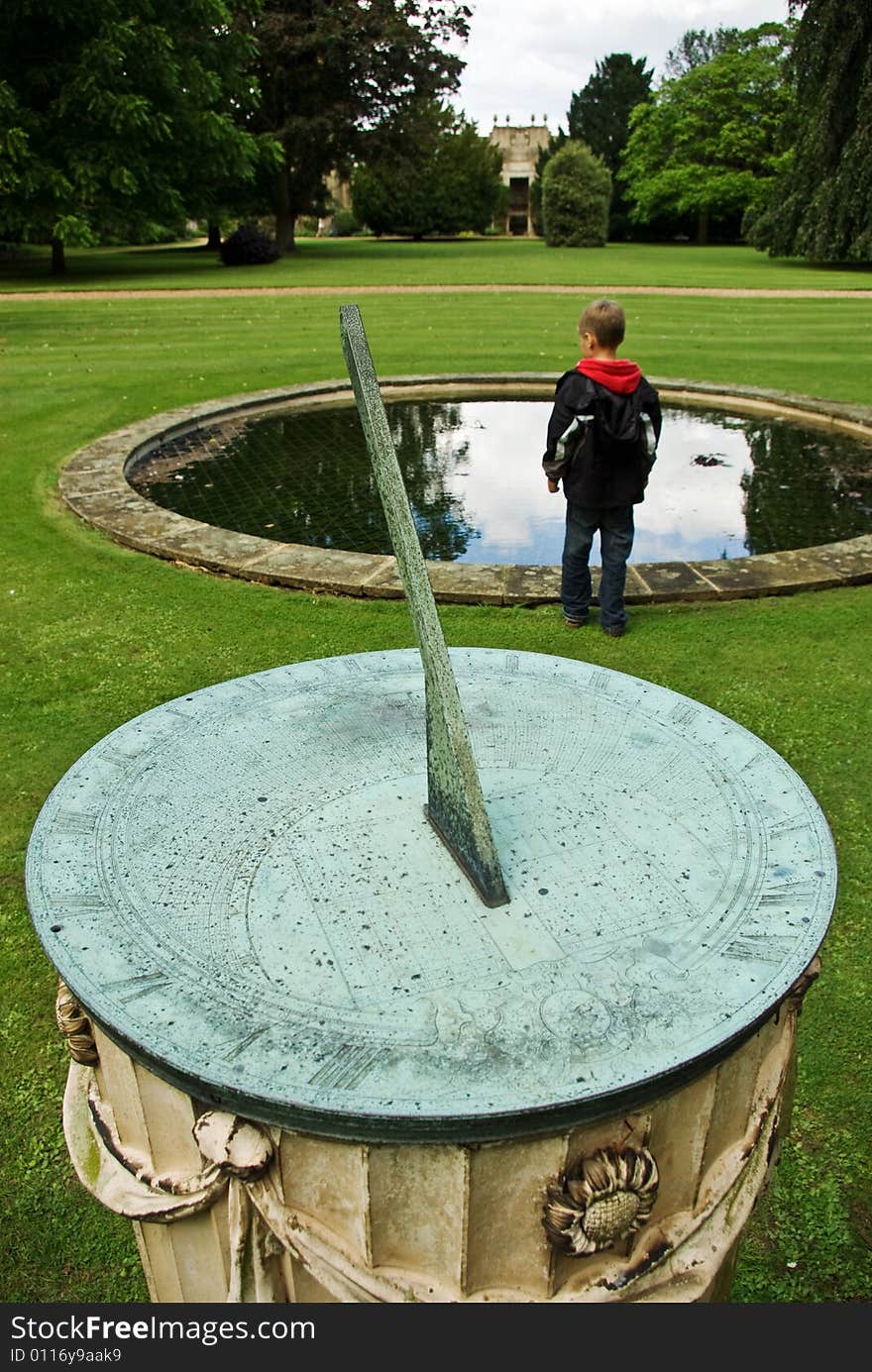 A boy stands beyond a classic sundial emphasising the fact that he will soon be grown up