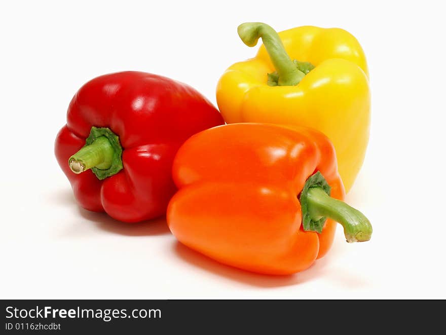 Red yellow and orange peppers on a white background