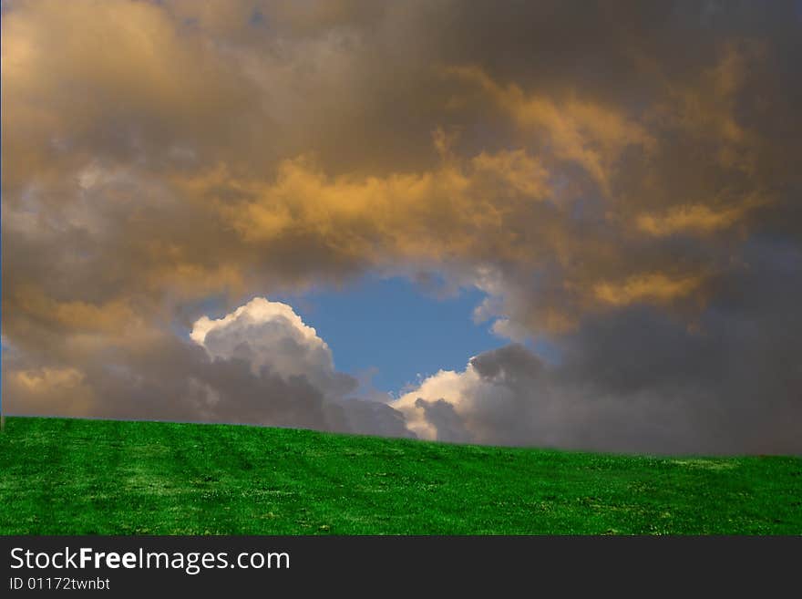 Composite picture of a hill in a park and sky taken the day before. Composite picture of a hill in a park and sky taken the day before.