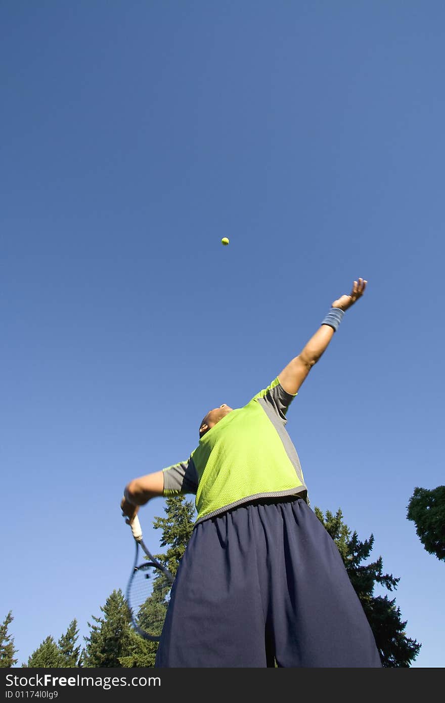 Man on Tennis Court Serving Tennis Ball