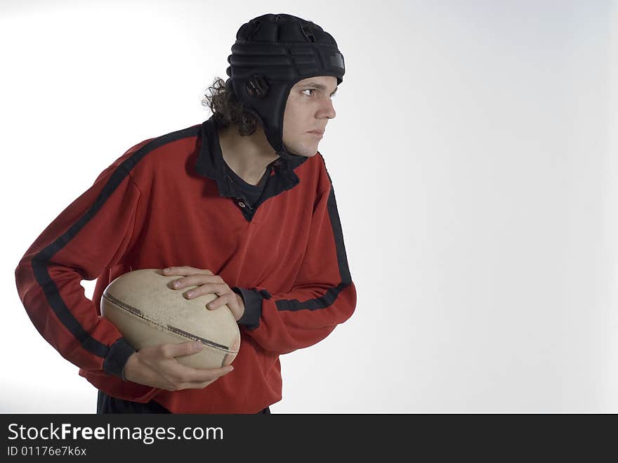 Rugby player holding a fooball with a serious look on his face. Horizontally framed photograph. Rugby player holding a fooball with a serious look on his face. Horizontally framed photograph