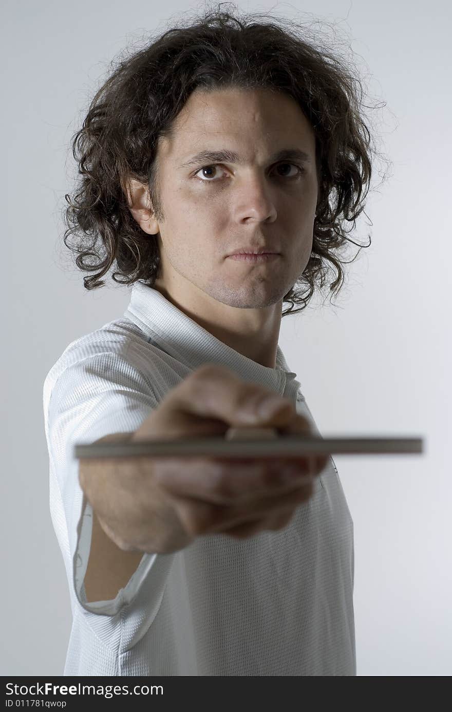 Man looks angry as he holds a table tennis paddle out in front of him. Vertically framed photograph. Man looks angry as he holds a table tennis paddle out in front of him. Vertically framed photograph