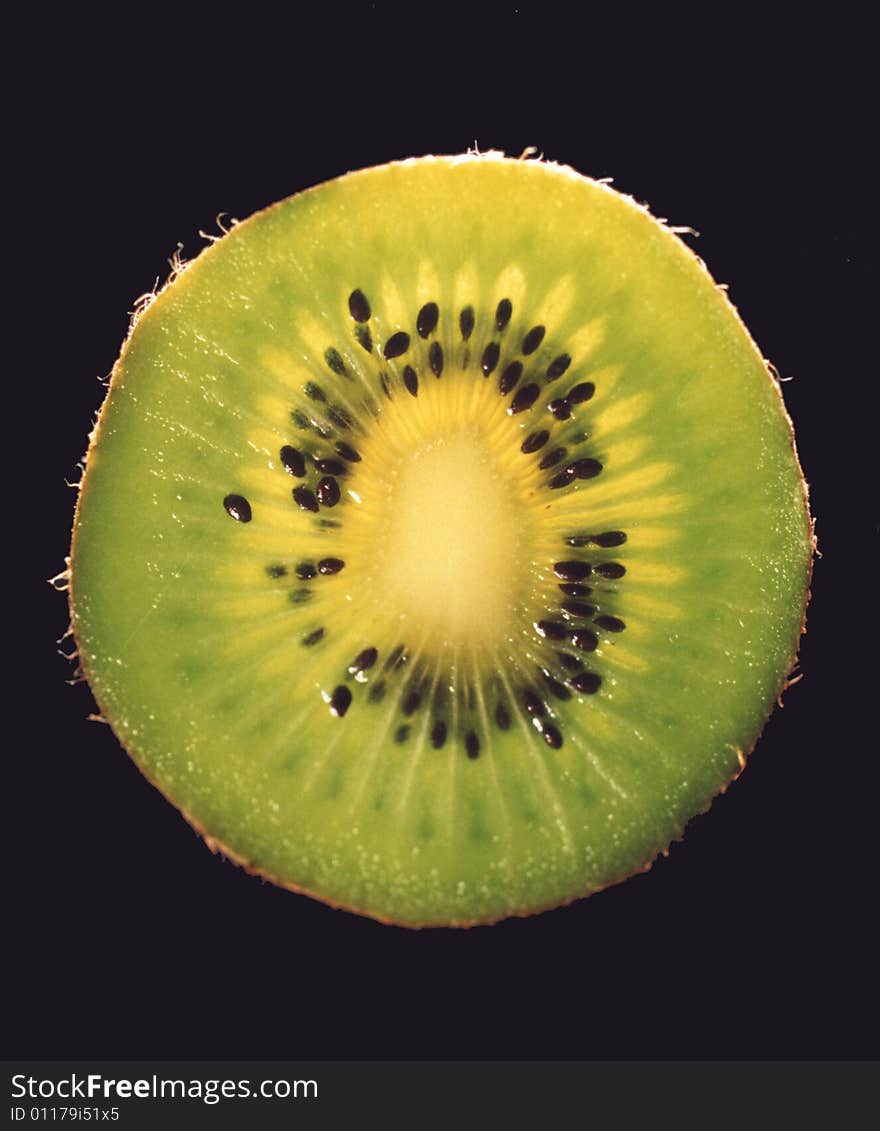 Photo of a sliced kiwi fruit exposing its seeds.