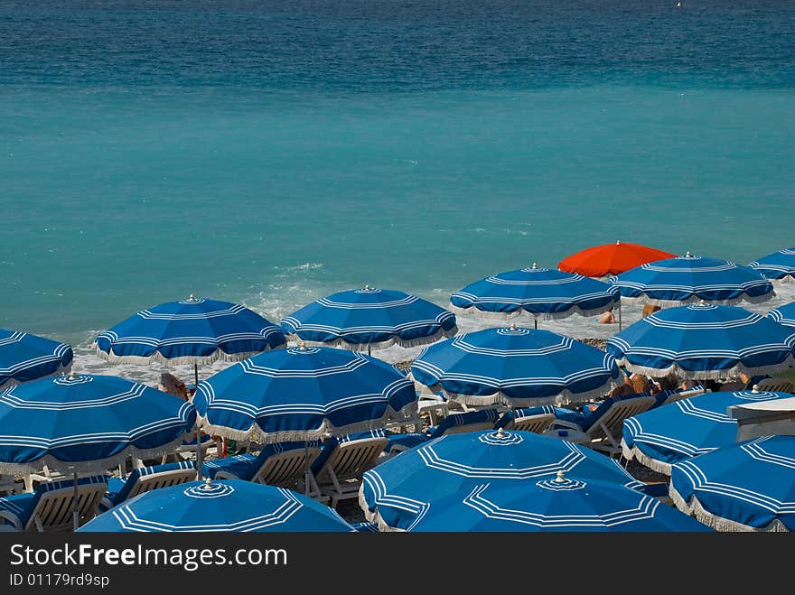 Red sunshade surrounded by blue ones