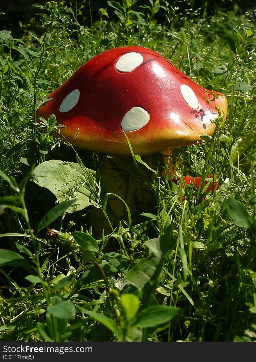 Ceramic fly agaric in herb in my garden. Ceramic fly agaric in herb in my garden