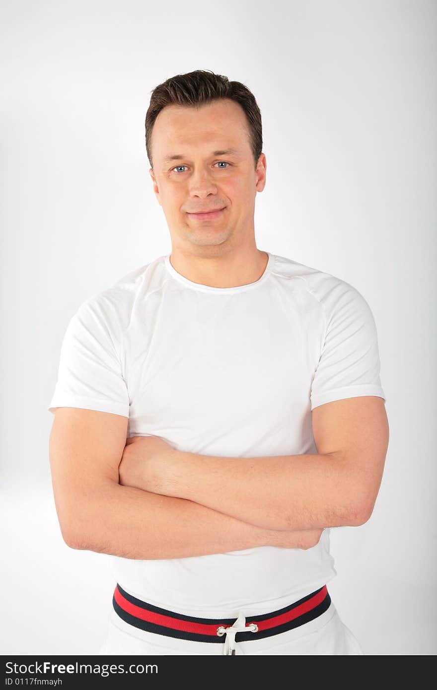 Man in white singlet with crossed hands