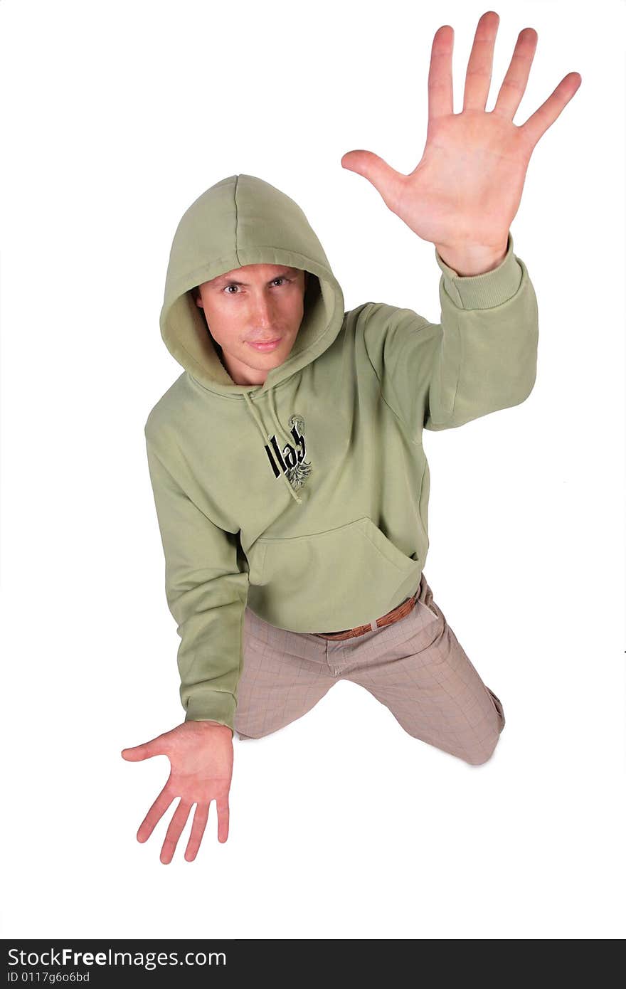 Man in jacket with hood is kneeling and has rised hand