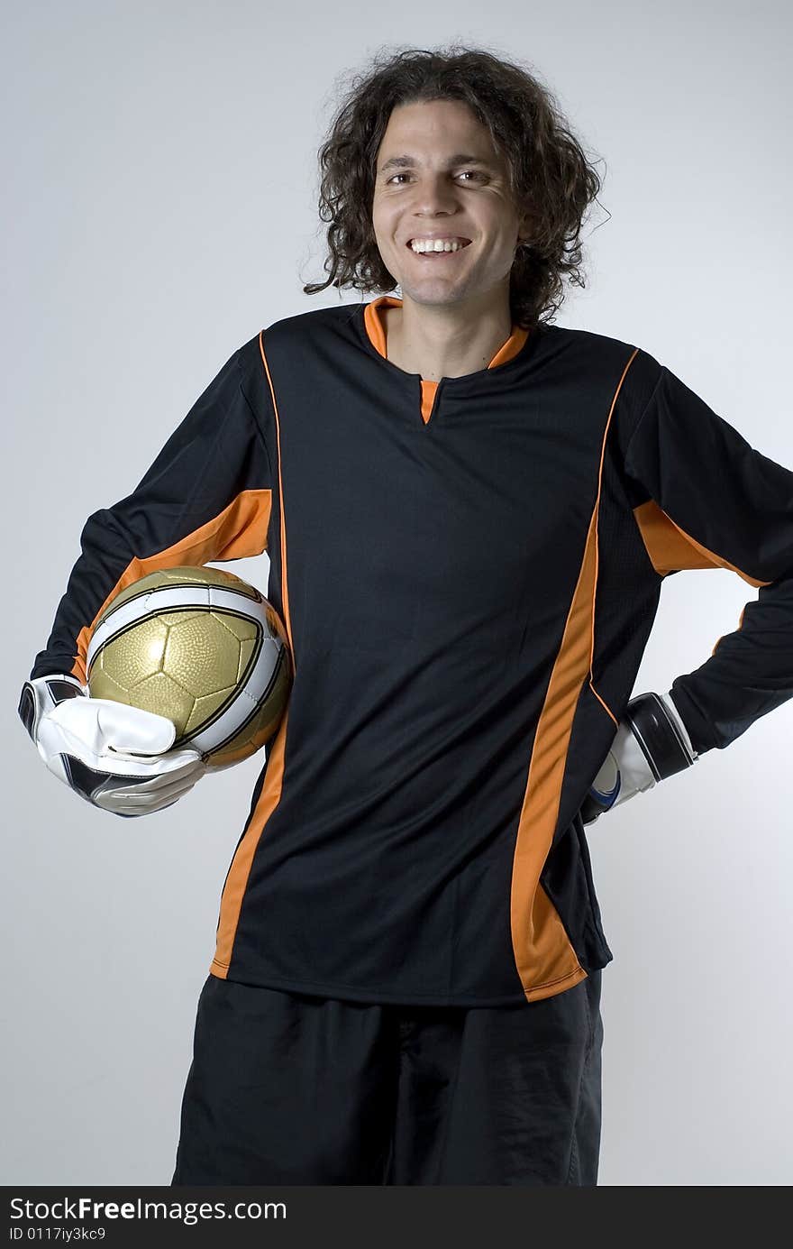 Goalie holding a soccer ball.  He is smiling and looking at the camera.  Vertically framed shot. Goalie holding a soccer ball.  He is smiling and looking at the camera.  Vertically framed shot.