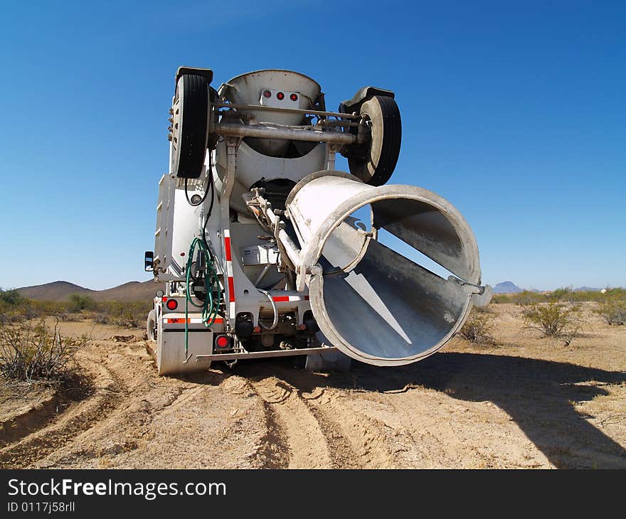 A cement mixing truck is parked in the desert. Horizontally framed shot. A cement mixing truck is parked in the desert. Horizontally framed shot.