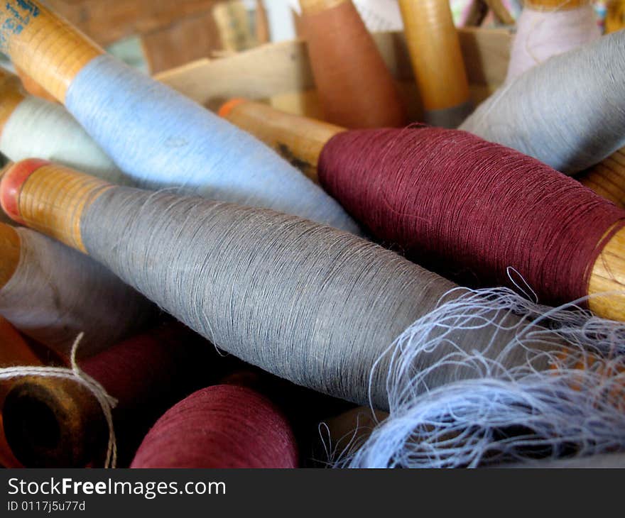 A variety of colors of yarn are inside a basket.  Horizontally framed shot. A variety of colors of yarn are inside a basket.  Horizontally framed shot