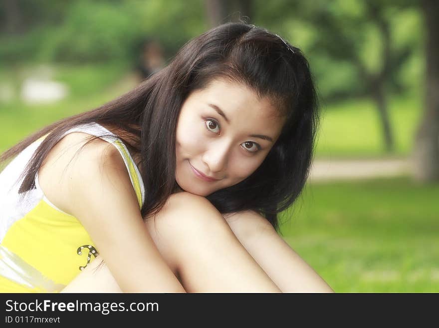 In summer, a lovely Chinese girl sits on the meadow. In summer, a lovely Chinese girl sits on the meadow.