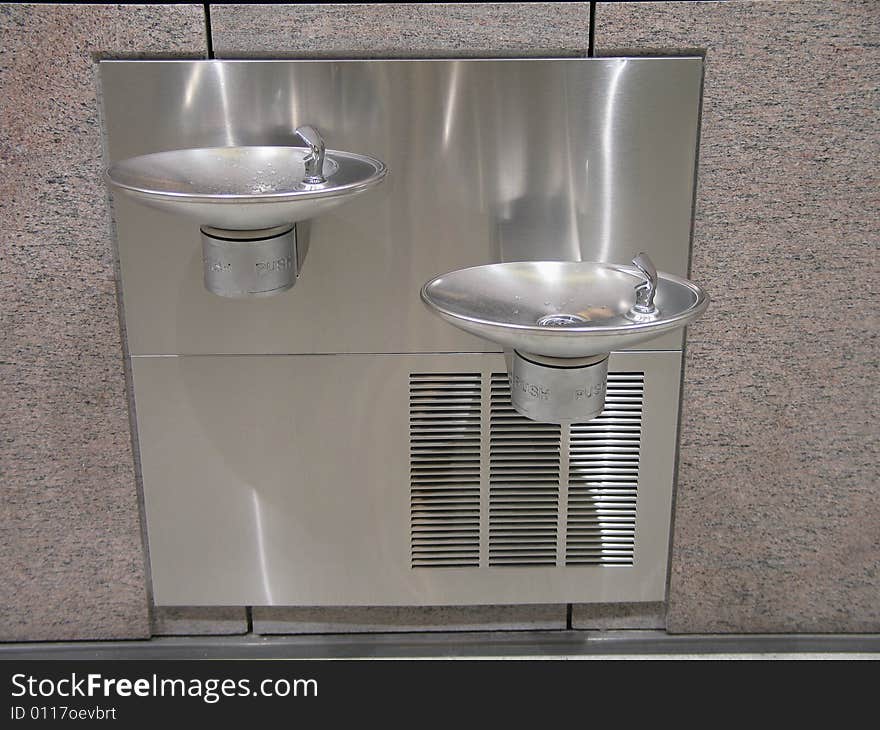 Silver double water coolers on a wall