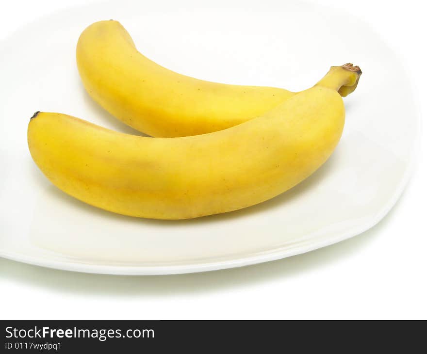 A bunch of fresh bananas on white plate and isolated on white background