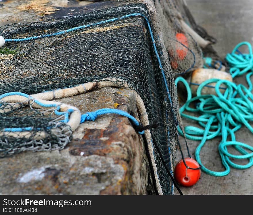 Fishing nets with floats drying on a wall in the harbour. Fishing nets with floats drying on a wall in the harbour