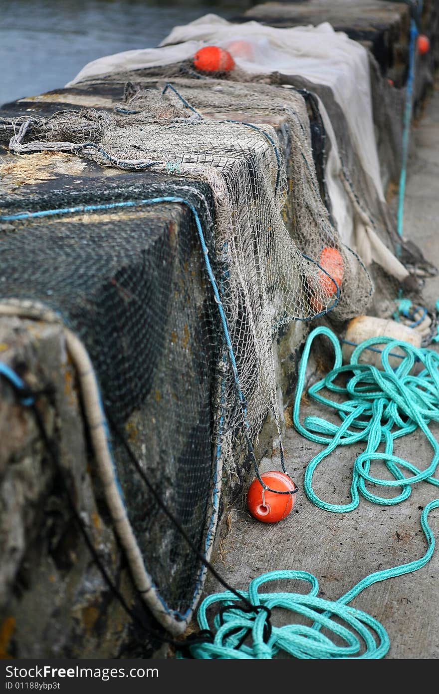 Fishing nets with floats drying on a wall in the harbour. Fishing nets with floats drying on a wall in the harbour